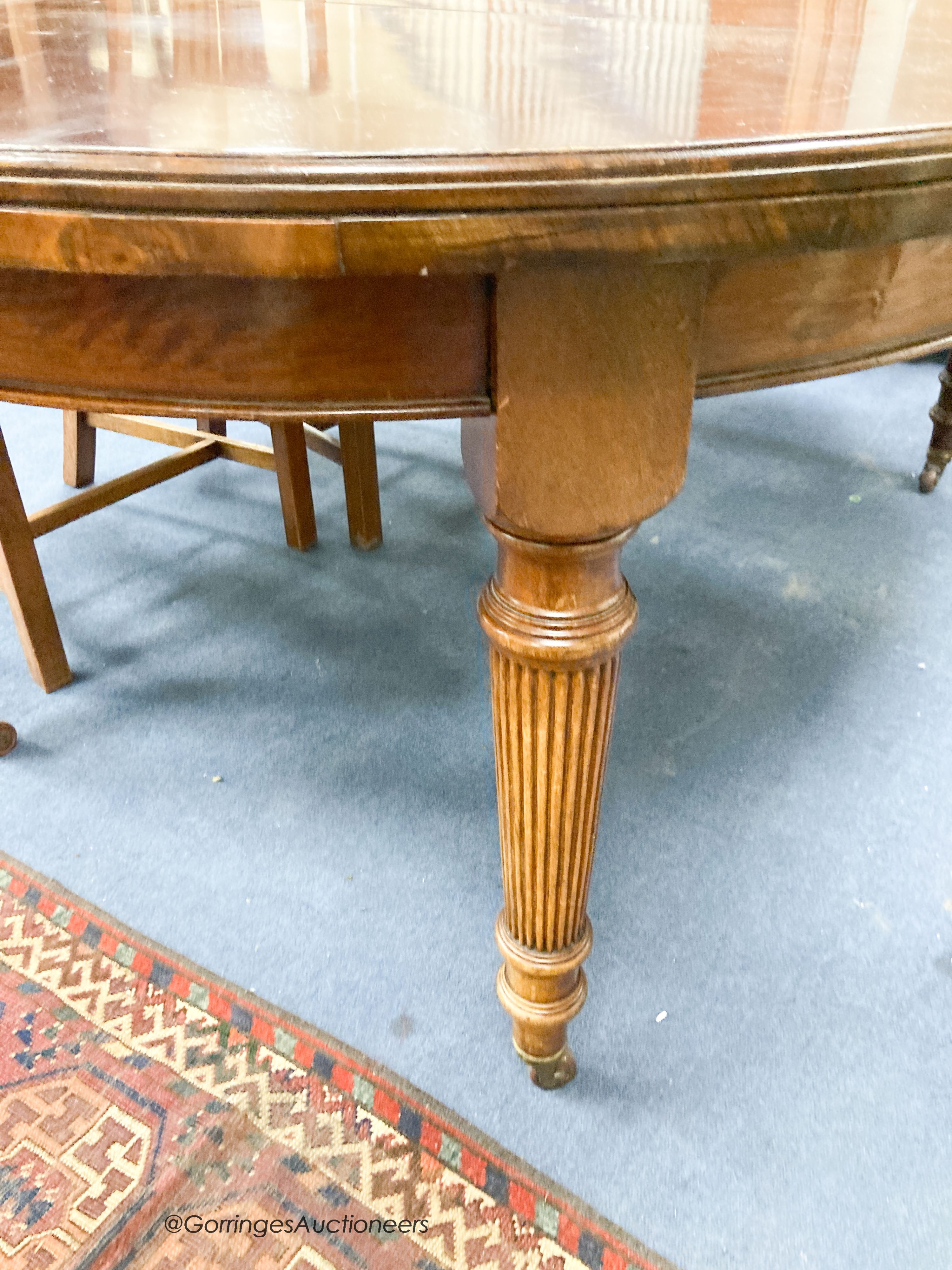 An Edwardian mahogany oval extending dining table, length 180cm extended with one spare leaf, width 120cm, height 74cm together with four George III style mahogany dining chairs